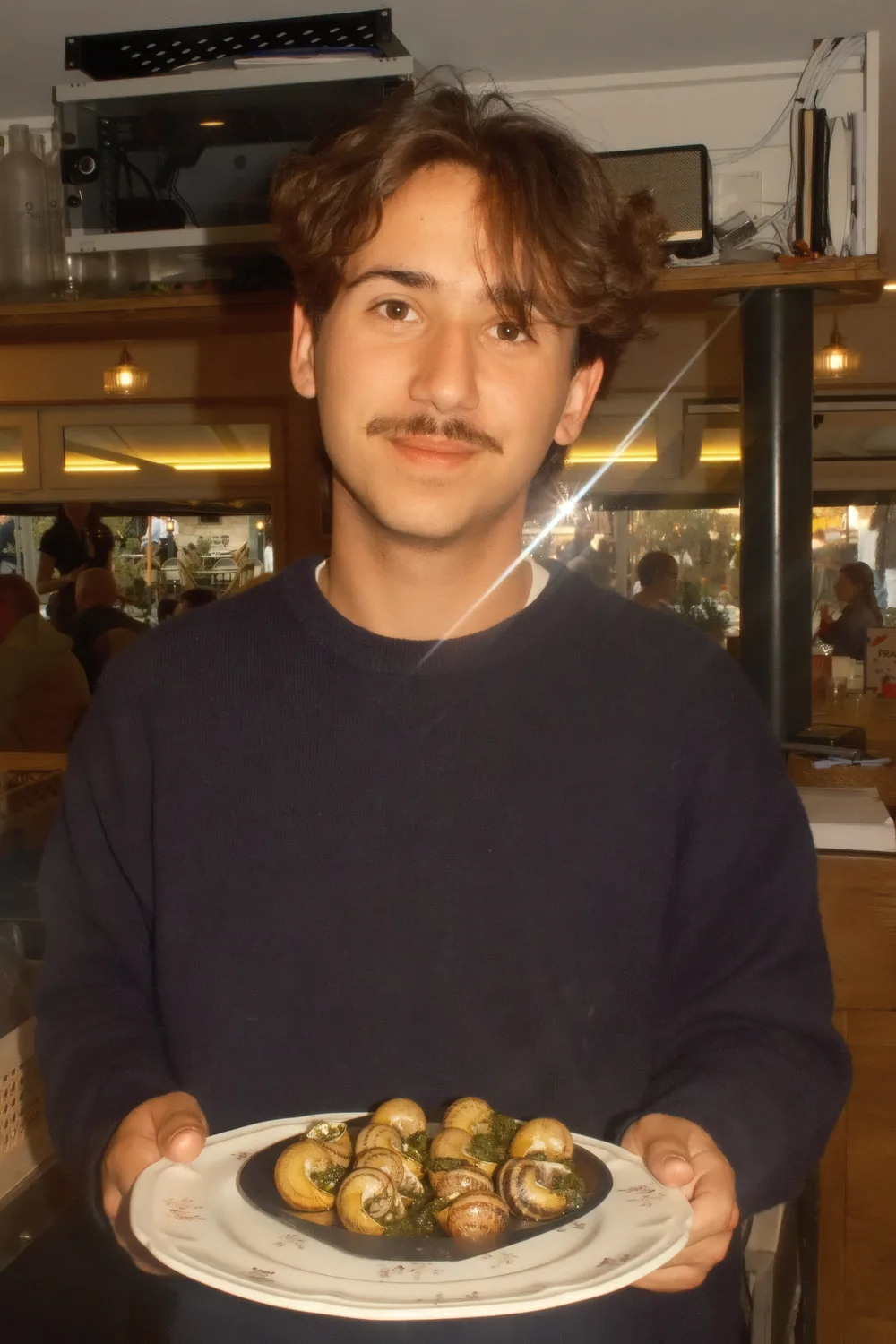 Un serveur des 4 Mâts portant une assiette